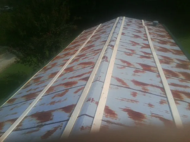 Rusted metal roof panels with new wood purlins before replacement — Storm Damage Roof Repair in Palmersville by Roofing Brothers