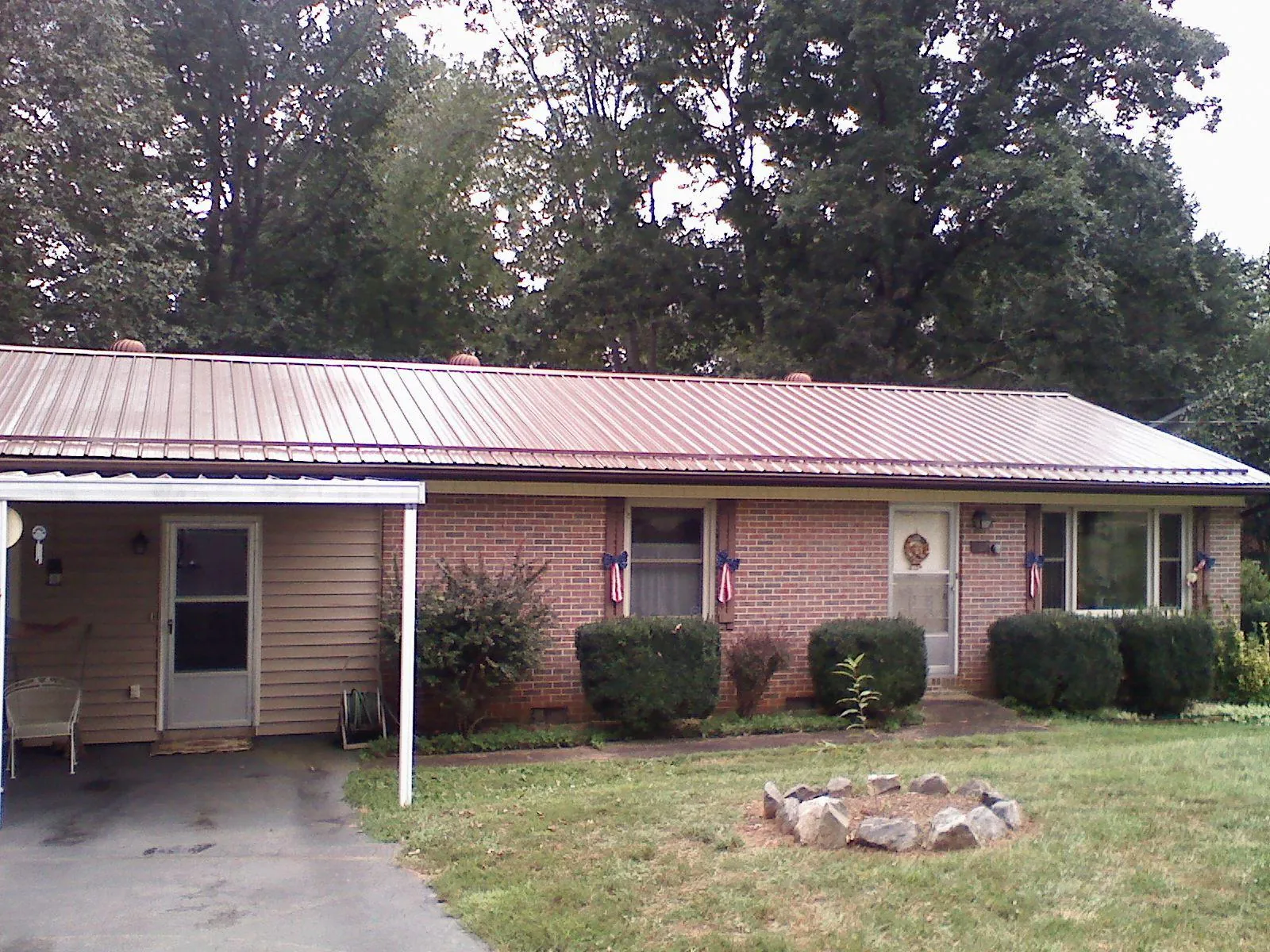 Bronze metal roof and carport on a brick ranch home — Roof Repair work by our crew in Palmersville